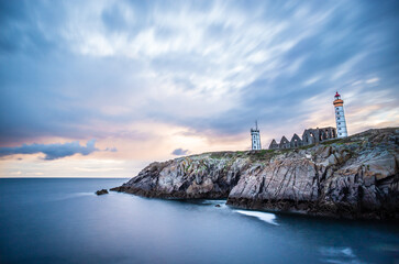 The ruins of the abbey of Saint-Mathieu and the lighthouse at the sunset in Brittany, France