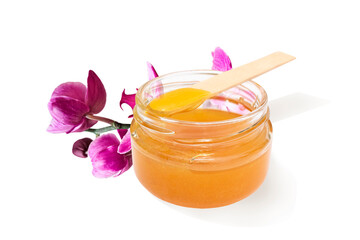 Liquid sugar paste for hair removal in bowl with orchid flower on white background.