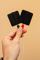 Electrodes. Electrotherapy in physiotherapy. Shock wave equipment for injury treatment. Human hand holding electrodes