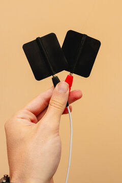 Electrodes. Electrotherapy in physiotherapy. Shock wave equipment for injury treatment. Human hand holding electrodes