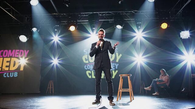 Stand-up comedian performing on stage in a comedy club at night  