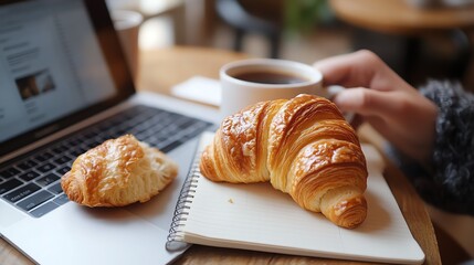 Cozy workspace with coffee and a croissant. Perfect for a relaxing break or a productive work session.
