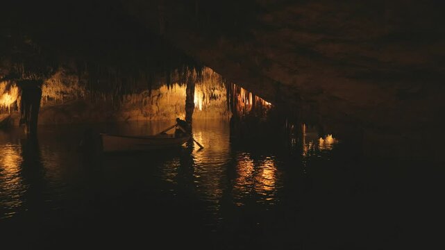 A man on a boat in the under water cave lake