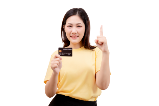 Asian young beautiful woman in a yellow shirt holds a credit card and points upward with her index finger.