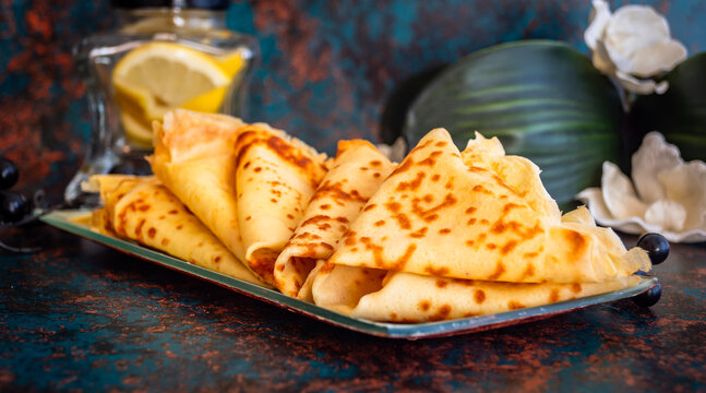 Pila de crepes caseras frescas con lim&oacute;n sobre fondo r&uacute;stico