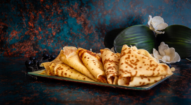 Pila de crepes caseras frescas con lim&oacute;n sobre fondo r&uacute;stico