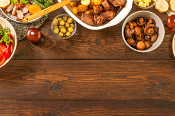 Dinner table concept. Top view of assorted grilled meat roasted potatoes mushrooms vegetables, copy space