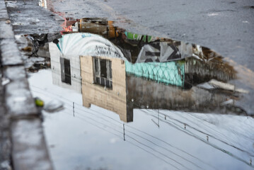 Reflection in a puddle of water of houses on a street in the city of Santo Amaro, Bahia.
