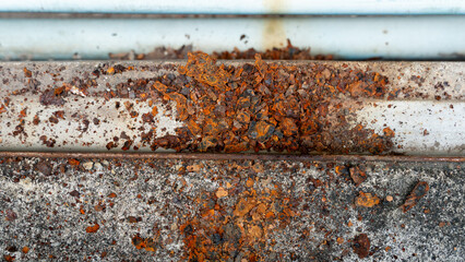 Heavily rusted and corroded metal surface. Layers of peeling. Reddish brown rust are prominent....