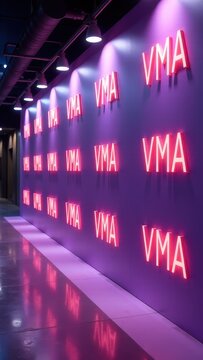 Neon vma wall with multiple illuminated pink signs in modern corridor.