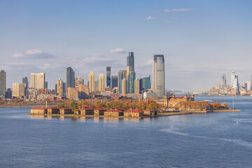 Panoramic view of Lower Manhattan skyline featuring One World Trade Center, seen from across the Hudson River on a clear day in New York City.