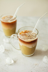 Trendy pistachio iced latte in a clear glass, on a white background with copy space – minimalist and refreshing aesthetic