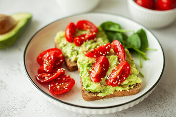 Wholesome vegan avocado sandwich on wholewheat bread, topped with fresh cherry tomatoes — a clean, nourishing choice for mindful eating and balanced living