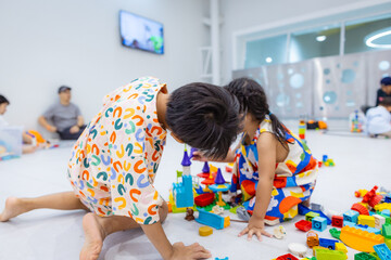 Kindergarten kids boy and girl enjoy toy block building