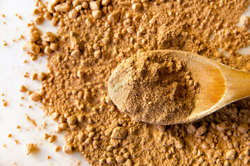 Cocoa Powder and Wooden Spoon on White Background – Top View with Texture