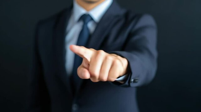 Confident and assertive businessman in dark suit and tie pointing hand gesture directly at camera, professional person showing leadership and decision making authority in formal office setting
