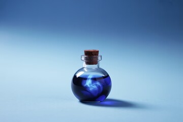 Mysterious blue potion in a glass bottle with a cork stopper still life