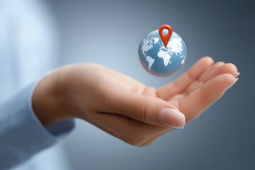 A hand holding a globe with a red dot on it. The globe is blue and white. The red dot is a marker for a location