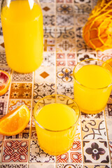 Fresh orange juice on table with slices fruits.