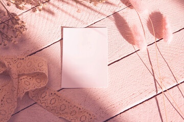 Copy space on white blank of paper on wood background, decorating with lace flowers in sunlight. Book, literature, paper, writing, texture and materials concept. Mockup template with copy space 