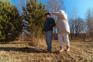 Romantic and elderly healthy lifestyle concept. Senior active Caucasian couple holding hands looks happy in park in autumn forest,happy anniversary,happily retired married couple together
