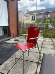 old red chair standing in the backyard of the house