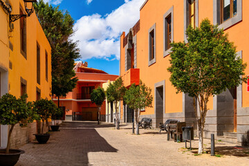 Colorful houses and trees at Plaza de Santo Domingo in Agüimes, Gran Canaria