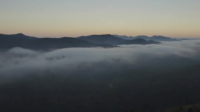 Fog covering forested mountains