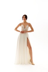 Elegant bride showcasing a stunning white gown with intricate detailing in a bright studio setting