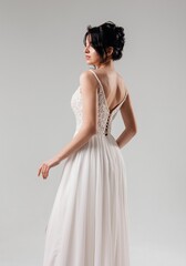 Elegant white dress showcased by a model in a studio setting during a fashion shoot