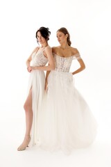 Naklejka premium Models showcase elegant bridal gowns in a bright studio setting during a fashion shoot in the afternoon