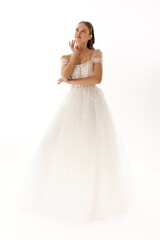 Fototapeta premium Model poses in elegant white wedding dress, showcasing bridal beauty in a soft, dreamy atmosphere during a fashion photoshoot