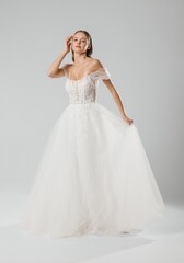 Fototapeta premium Elegant wedding dress showcase featuring a model in a designer gown on a neutral background