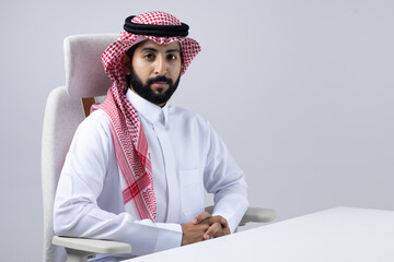 A collection of images of Arab business professionals, both male and female, in traditional clothing working together in a modern office setting, using laptops, discussing projects, and collaborating 