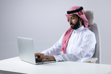 A collection of images of Arab business professionals, both male and female, in traditional clothing working together in a modern office setting, using laptops, discussing projects, and collaborating 
