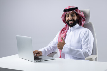A collection of images of Arab business professionals, both male and female, in traditional clothing working together in a modern office setting, using laptops, discussing projects, and collaborating 