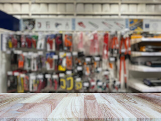 Wooden table top (counter bar) with blured Hand tools on shelf display at store for background. Banner for advertise on online media. For montage product display visual layout. Shopping concepts.