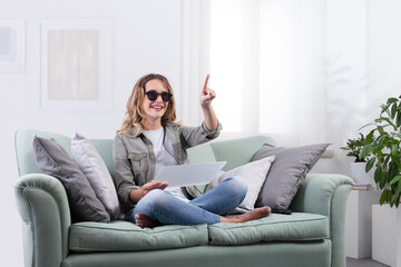 Fototapeta premium Smiling young woman using smart glasses and digital devices at home