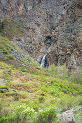 Mountain cliffs surrounding Chulyshman valley with visible waterfall Altai Russia Dramatic natural landscape with high rocks and falling water
