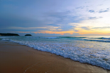 Fototapeta premium Serene Evening Beach Scene with Gentle Waves and Colorful Sky at Sunset