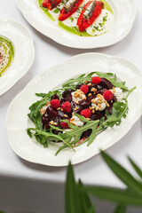 Portion of gourmet beet salad with cheese and arugula on served table