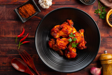 Air Fryer spicy marinated chicken drumettes in black plate.Healthy cooking low calorie.