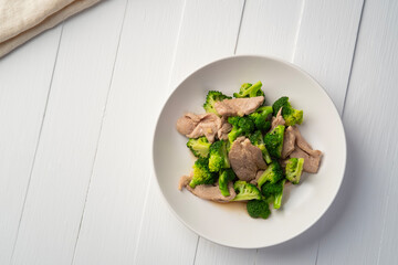 Stir fried broccoli with pork tenderloin fillet in white plate.Thai Healthy food for low fat diet menu.Top view