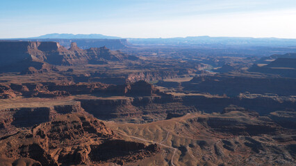 Panorama of picturesque famous grand canyon of Colorado river with red orange sandstone rocks buttes in light of sunset. Deadhorse national park, popular tourist destination. View from height point
