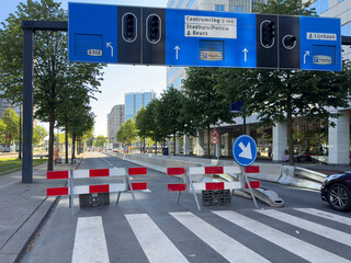 Road works in the city center, street lanes closed, traffic lights and detour signs, modern...