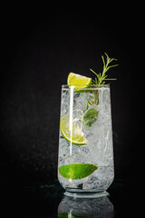 Mineral water with lime, ice and rosemary on a black background, detox soda water recipe
