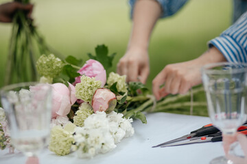 close up of female hands arranging wedding bouquet