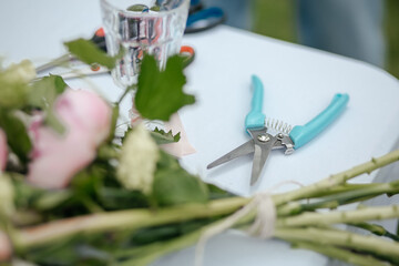 table with flowers and supplies for making bouquets