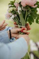 close up of female hands arranging wedding bouquet