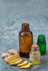 Bottles of essential oils with fresh ginger slices